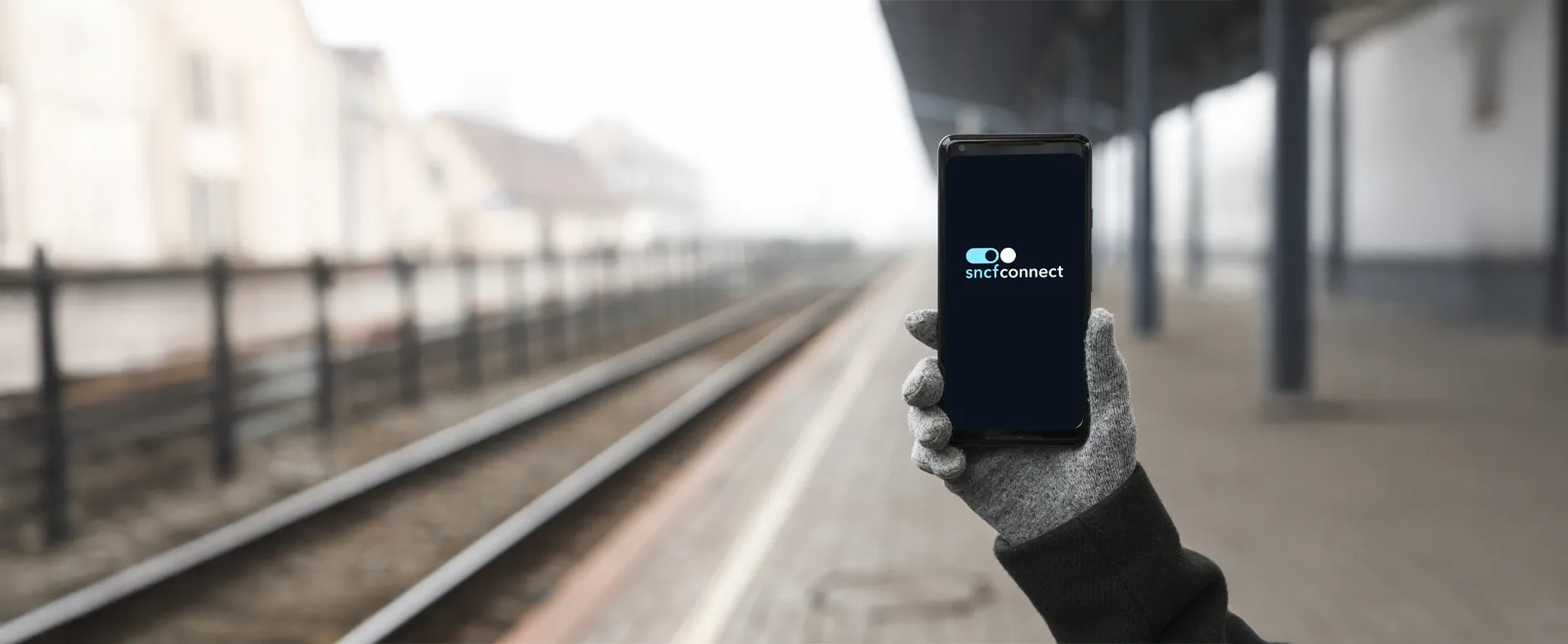 Smartphone dans une gare avec le logo SNCF Connect